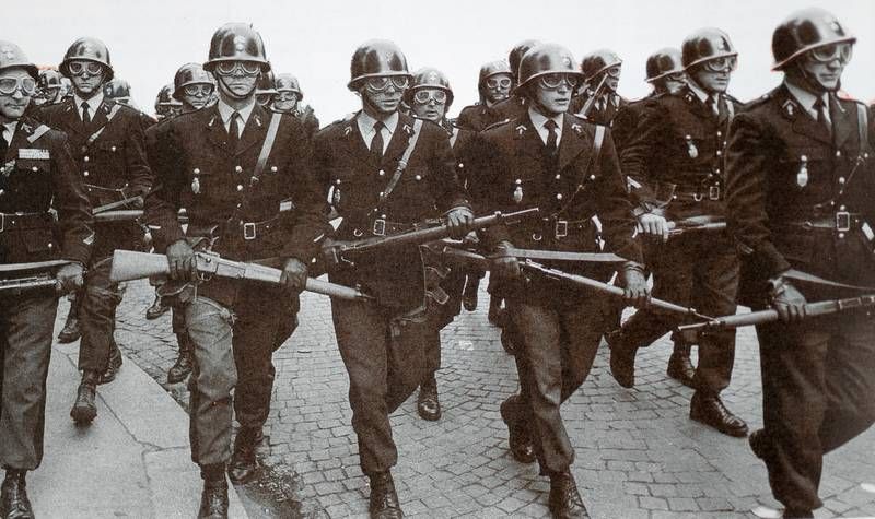Policiers en rang portant un fusil
